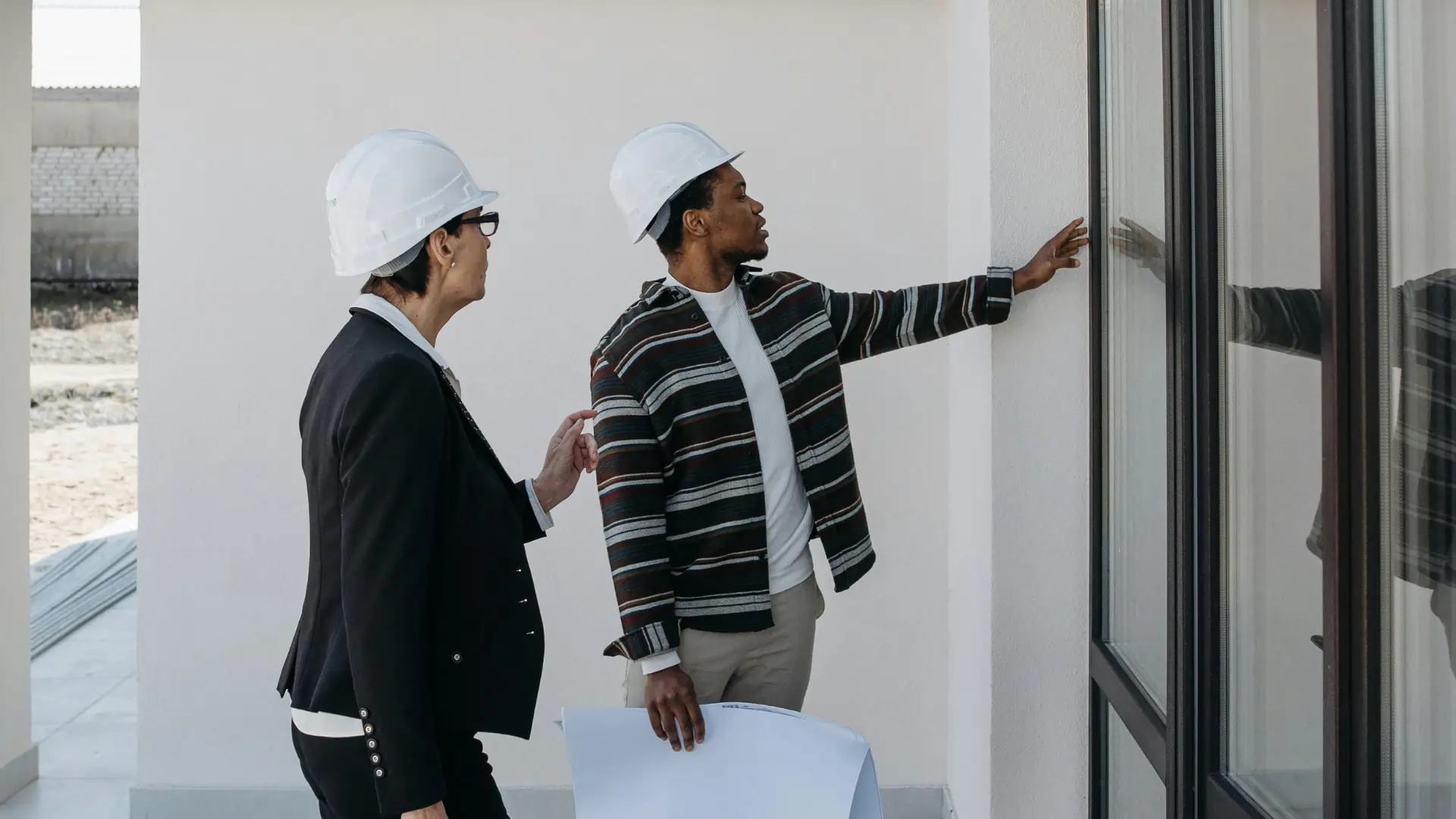 Inspector and property manager reviewing building exterior for national housing compliance