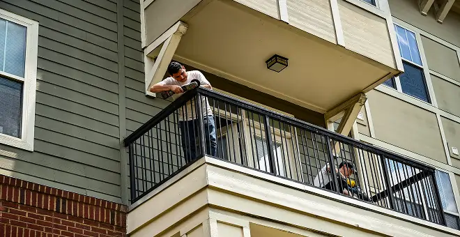 Apartment maintenance staffing team repairing balcony at multifamily property