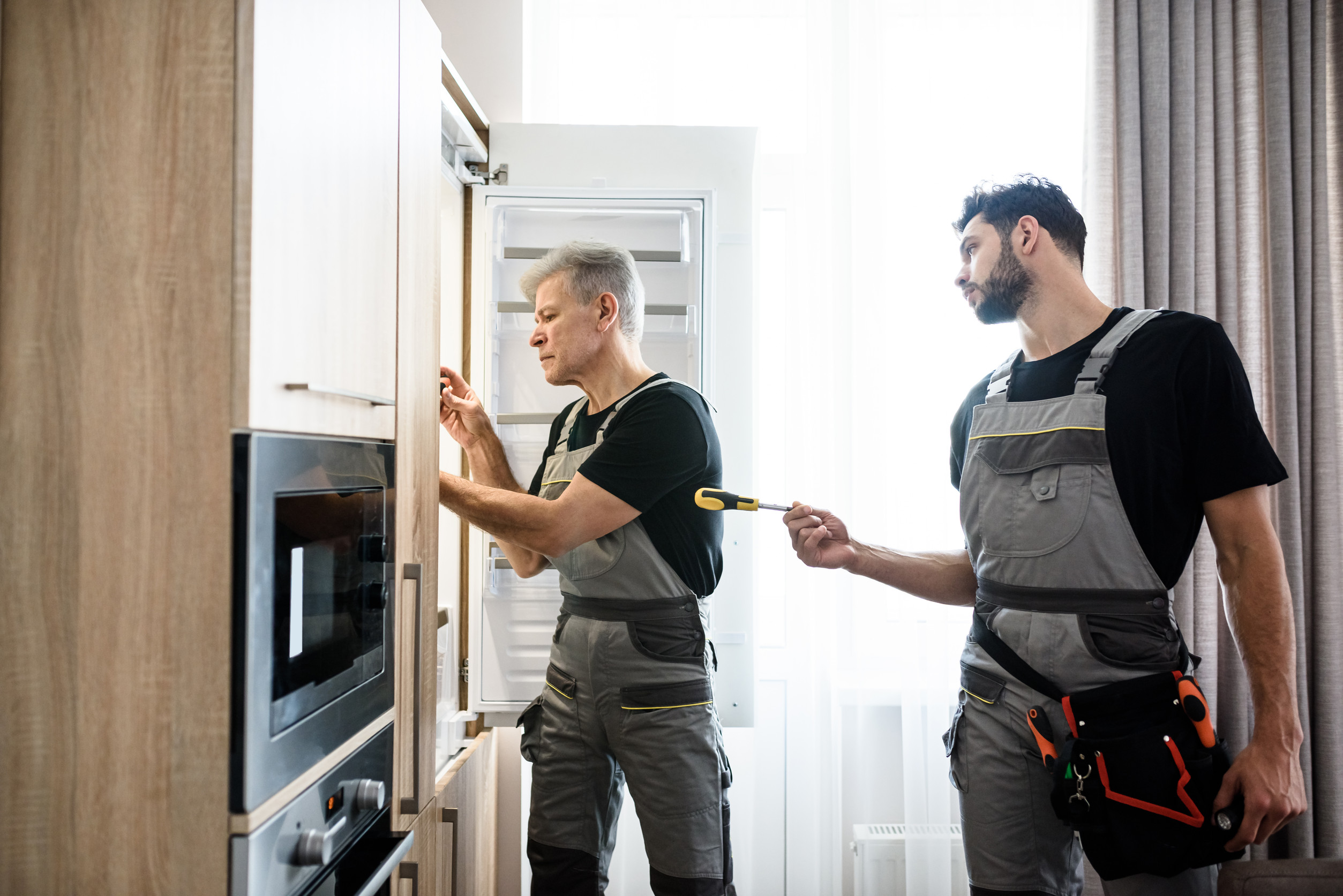 Technicians from an apartment maintenance staffing agency repairing a unit kitchen