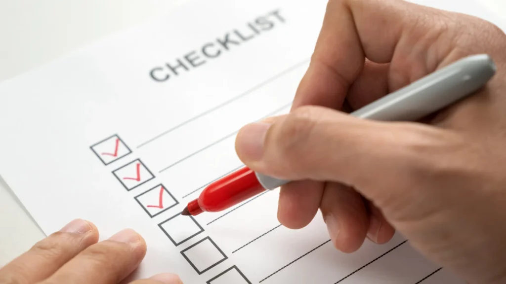 Hand marking items on NSPIRE inspection checklist for HUD compliance
