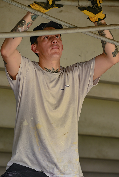 NSPIRE Expert checking overhead piping during HUD inspection prep