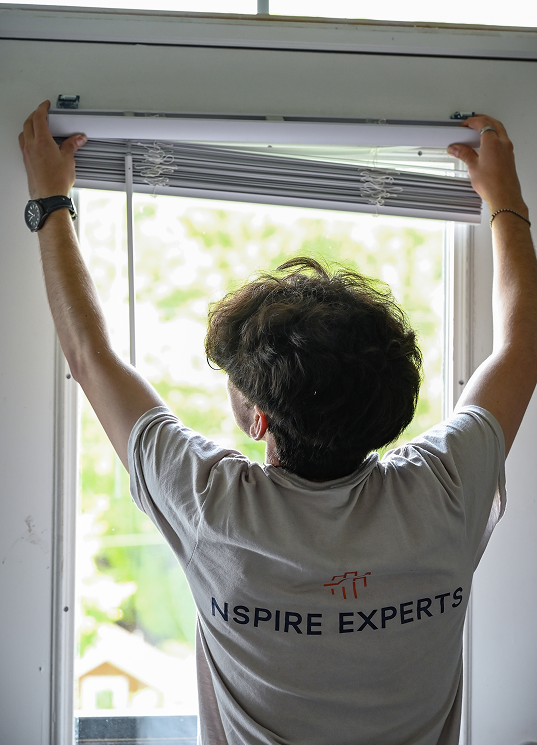 NSPIRE Expert adjusting window blinds to prepare unit for HUD inspection